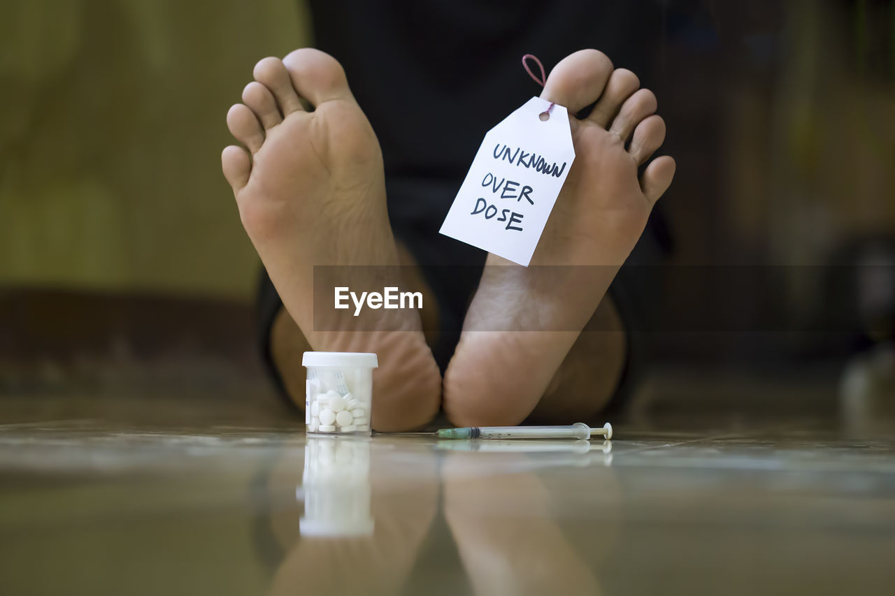 Low section of dead man lying on floor