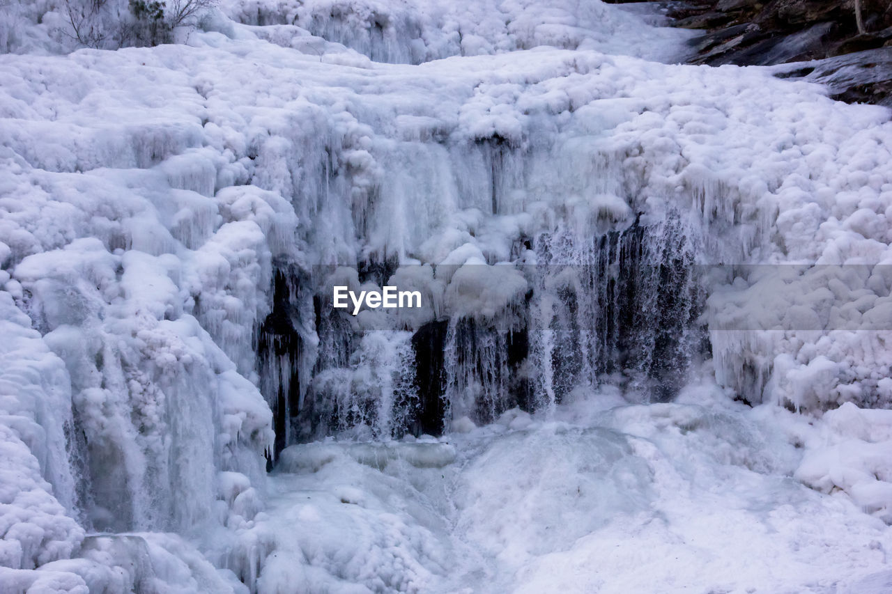 SCENIC VIEW OF WATERFALL IN SNOW