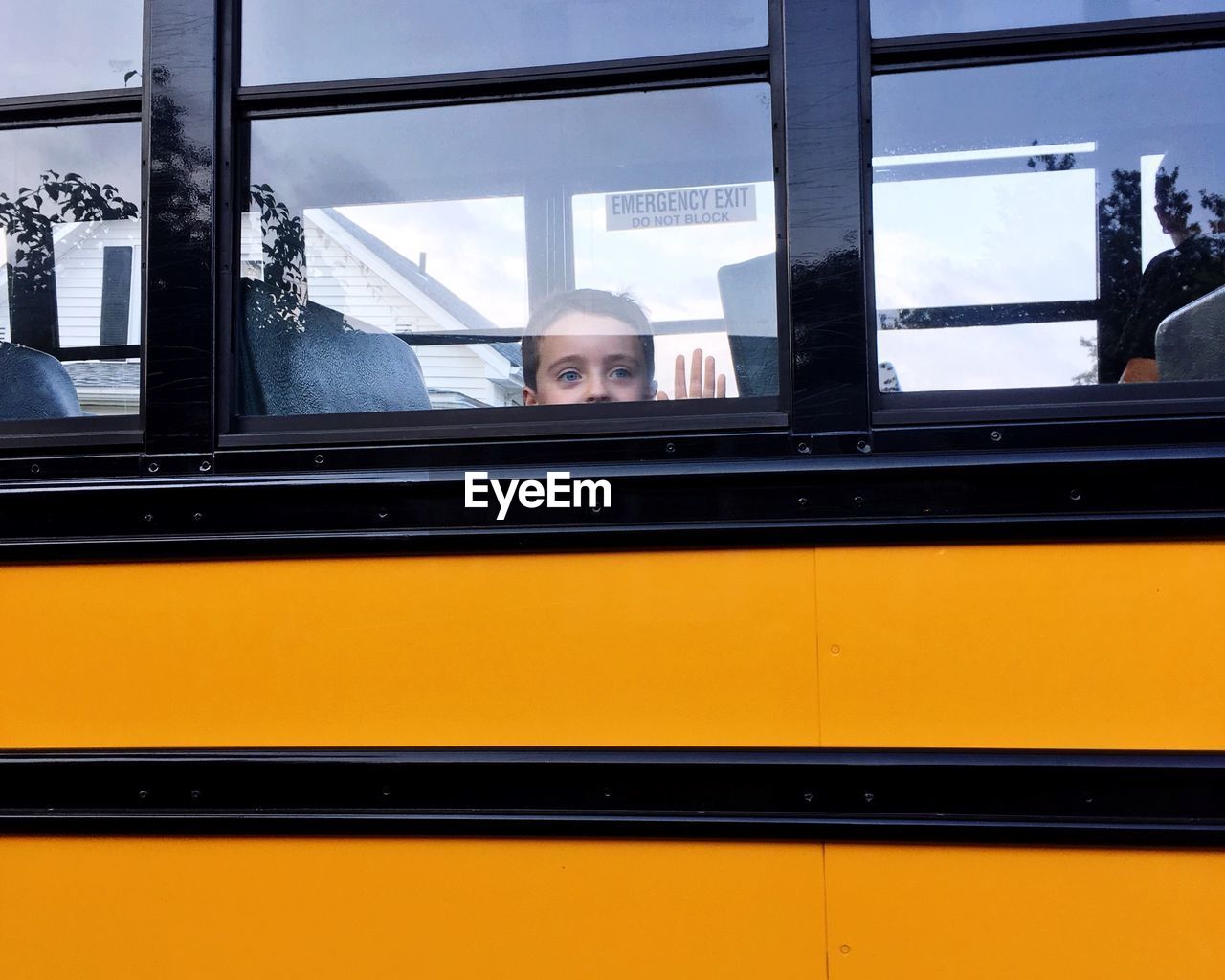 Boy looking through window of bus