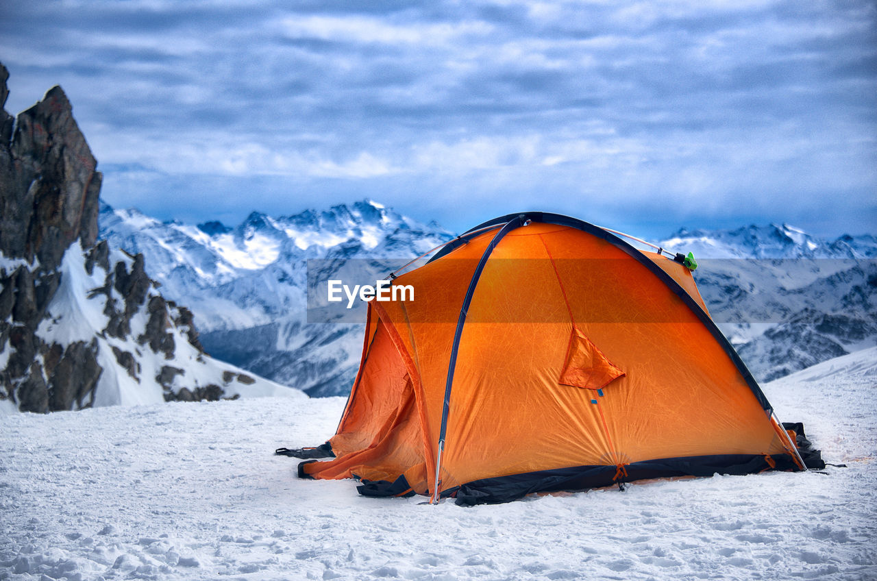 Tent on snow covered mountain against sky