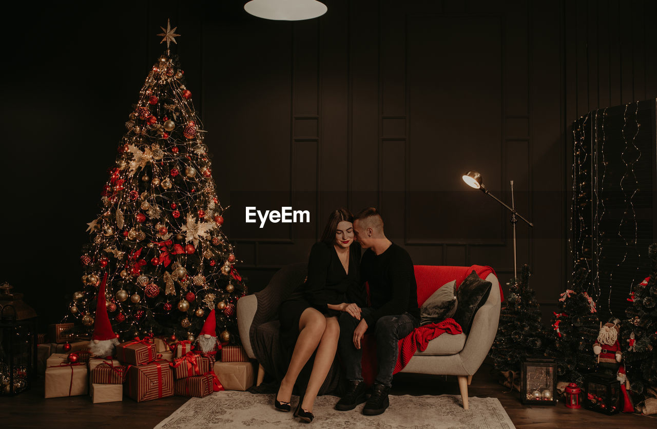 Couple using mobile phone while sitting at home