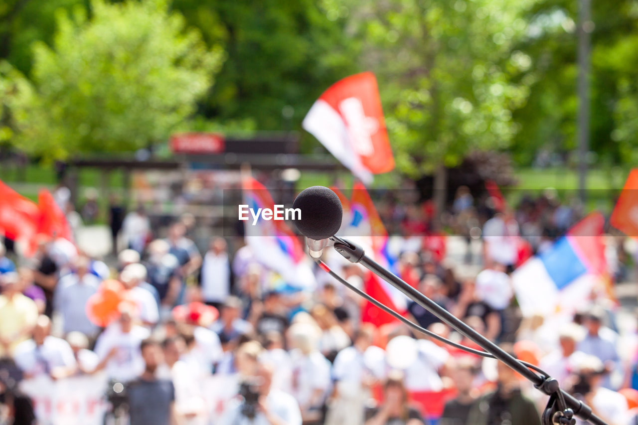 Political protest or public demonstration, focus on microphone, blurred crowd in the background