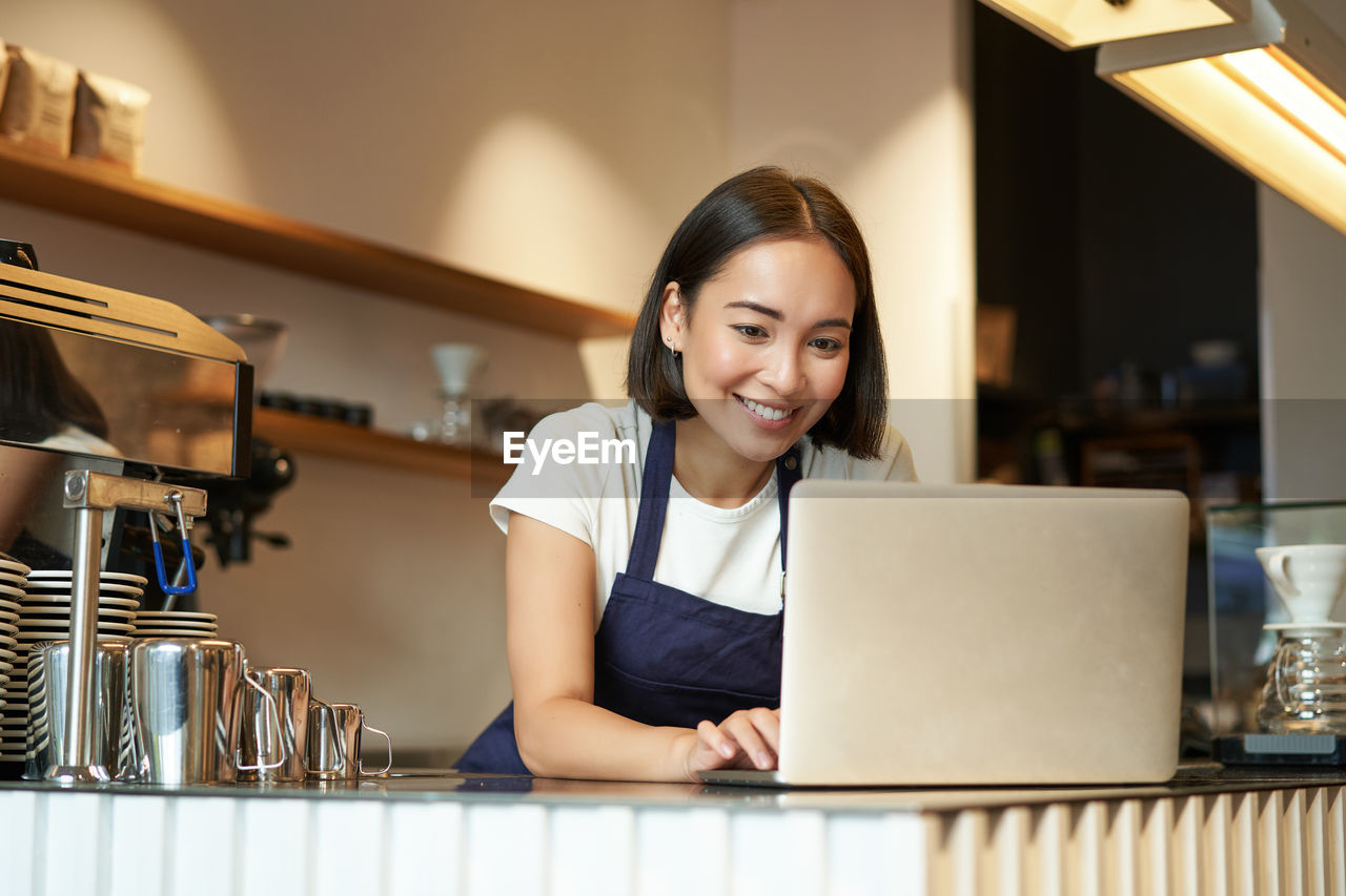 portrait of young woman using laptop on table