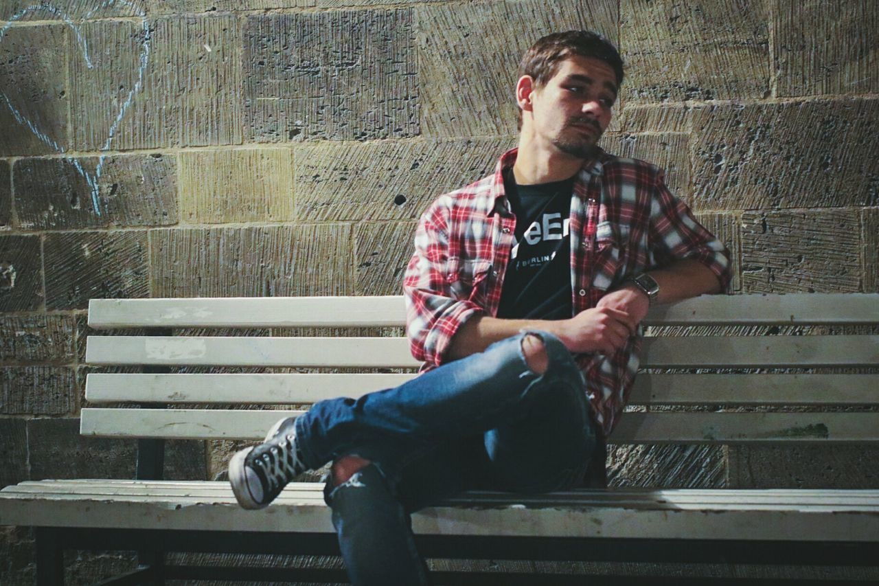 Thoughtful man looking away while sitting on bench