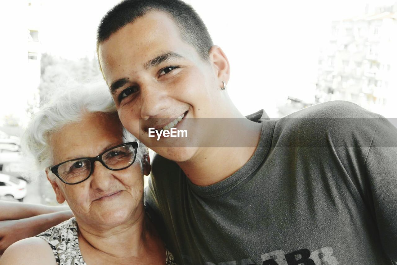 Portrait of happy young with grandmother at home