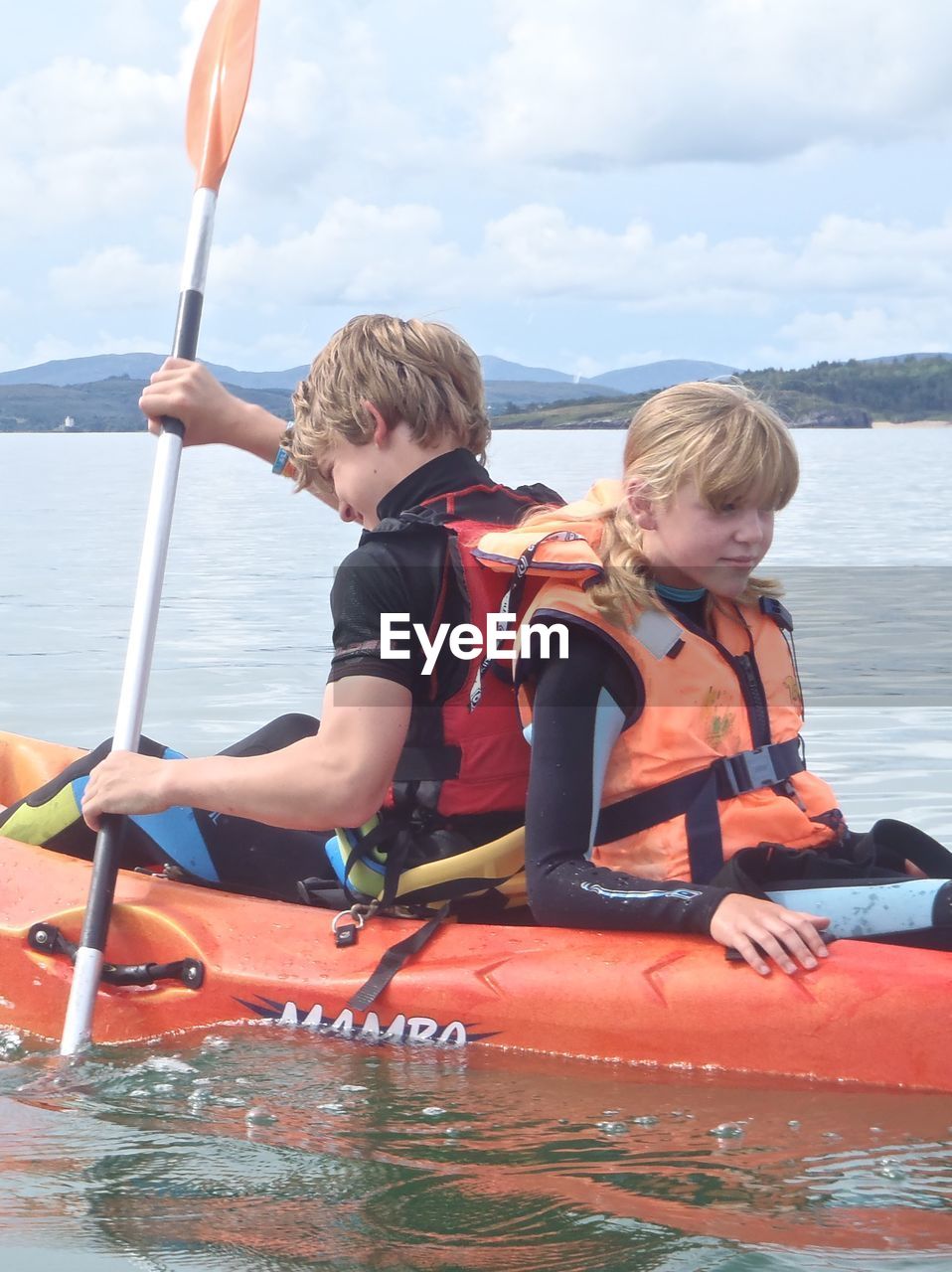 FRIENDS ENJOYING ON BOAT AGAINST SKY