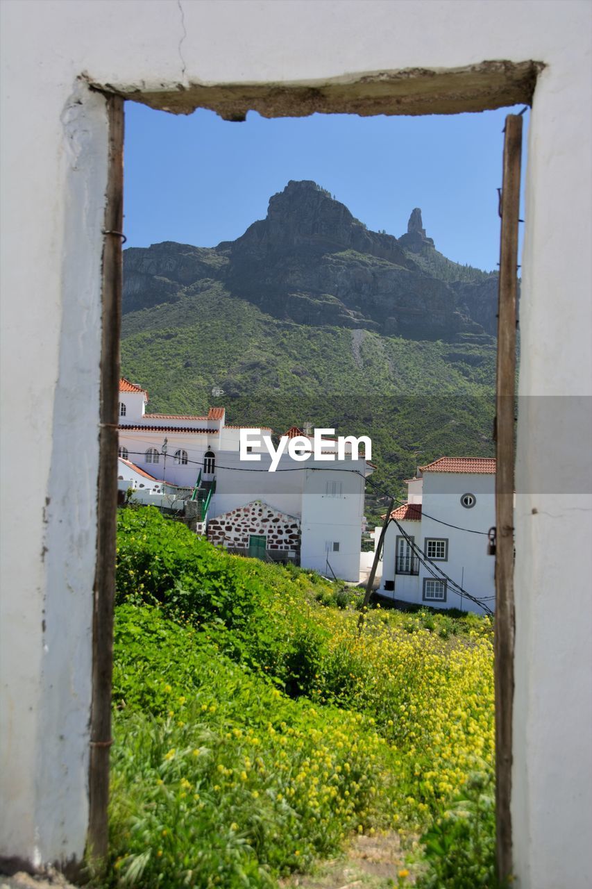 Buildings by mountains against sky
