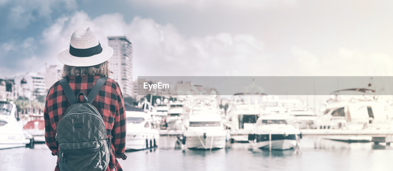 MAN STANDING IN CITY AGAINST SKY IN BACKGROUND