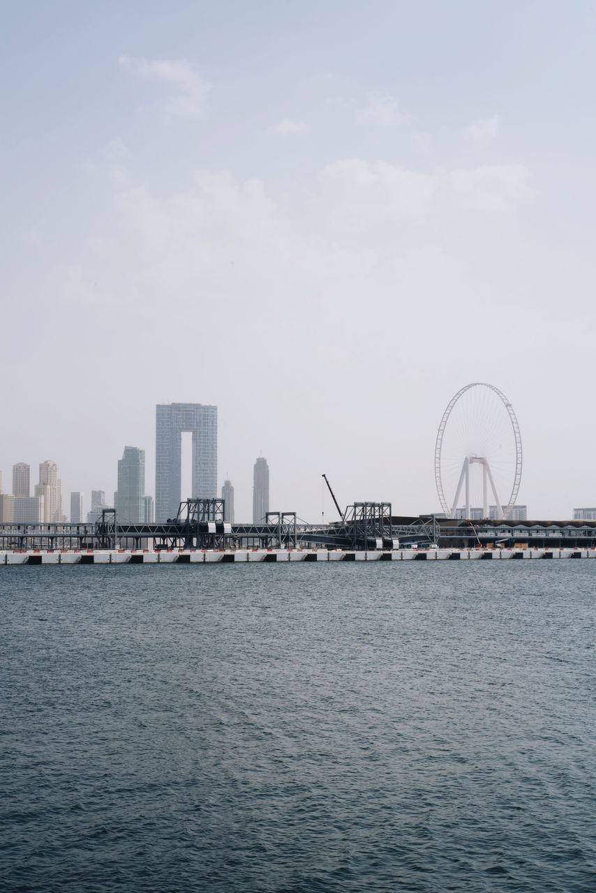 Scenic view of sea by city against sky