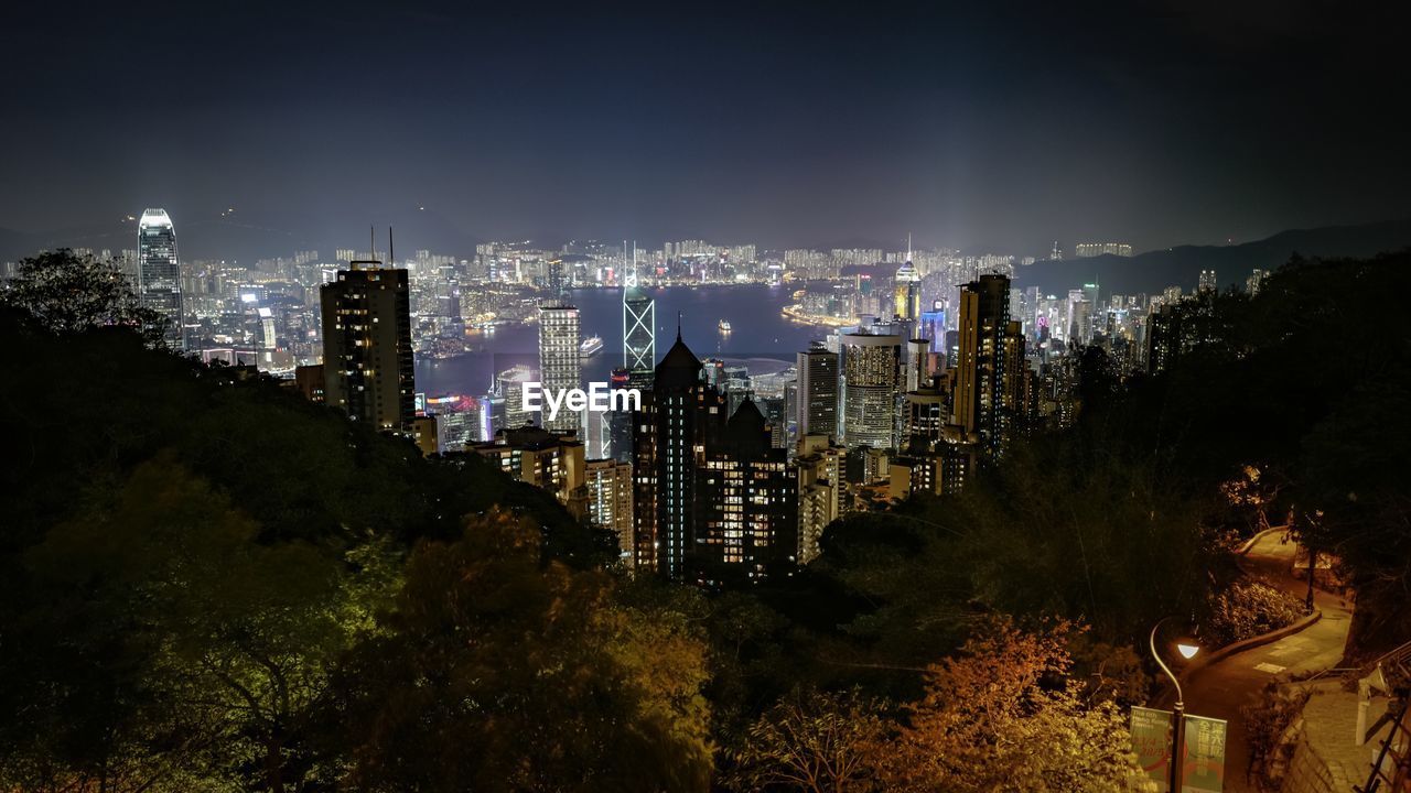 High angle view of illuminated city by victoria harbour at night