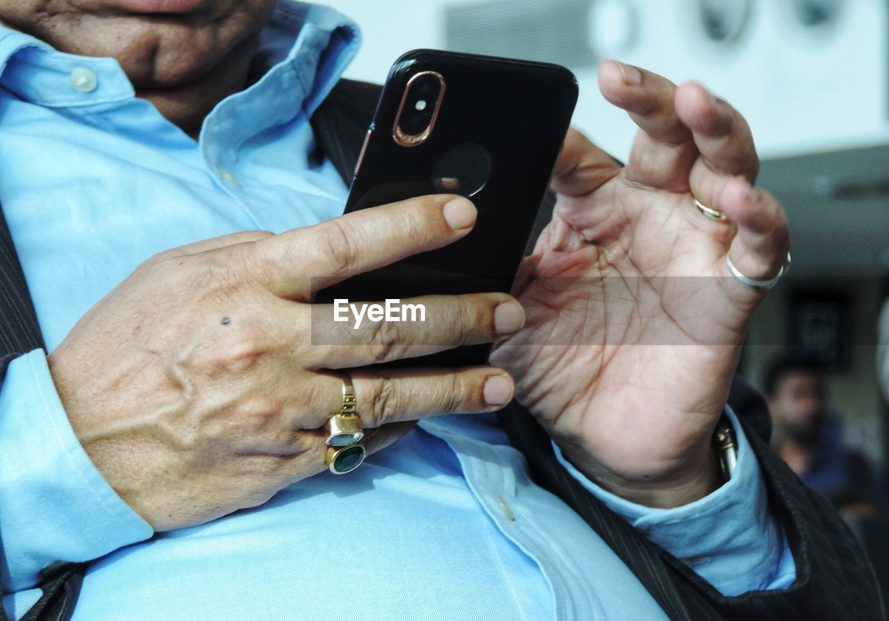 Midsection of man using mobile phone