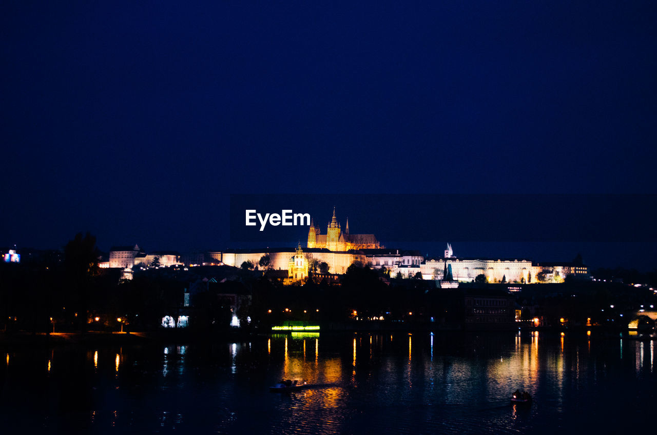 A dark evening in prague with incandescent lights illuminating the city.