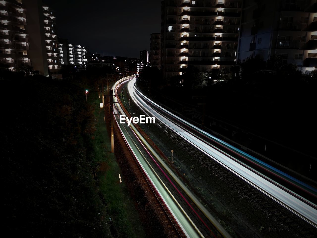High angle view of light trails on street amidst buildings in city