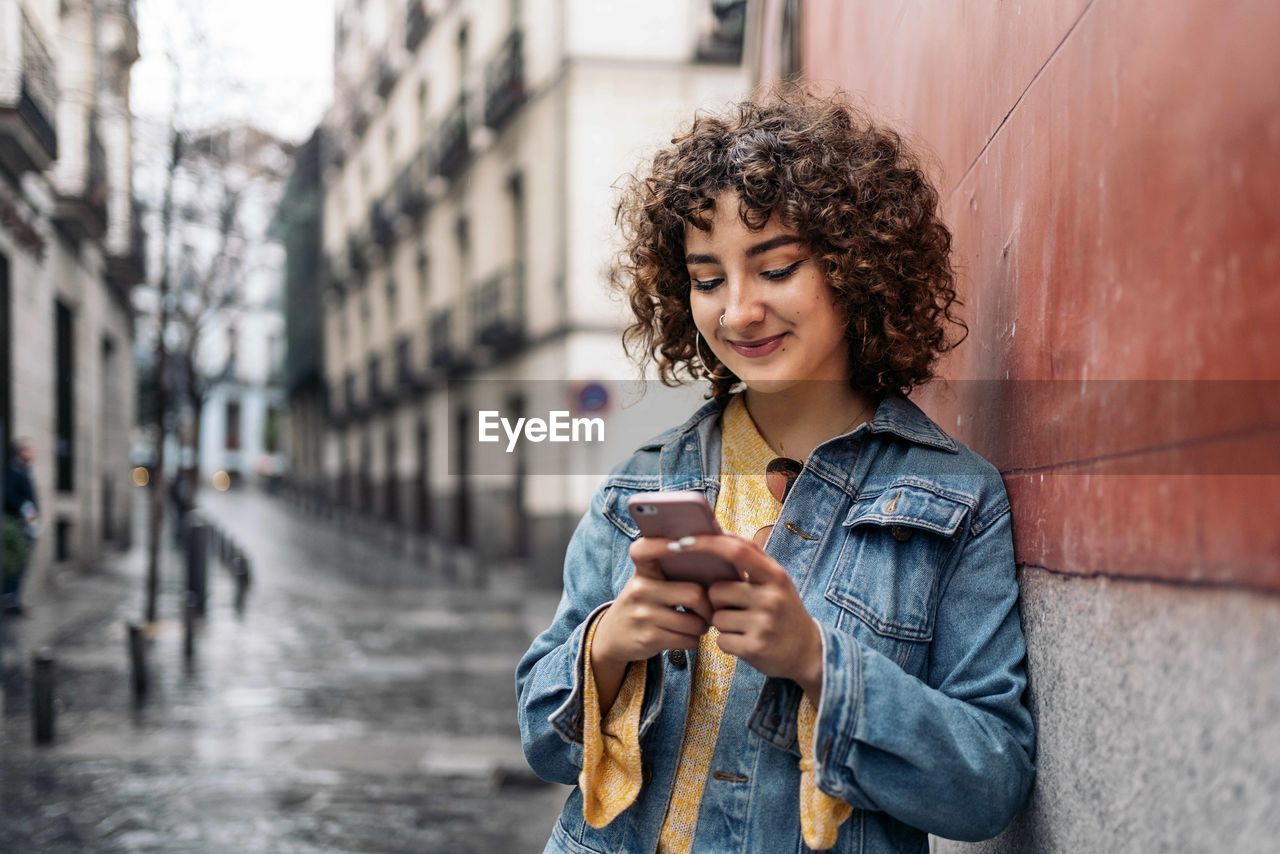 Young woman using mobile phone in city