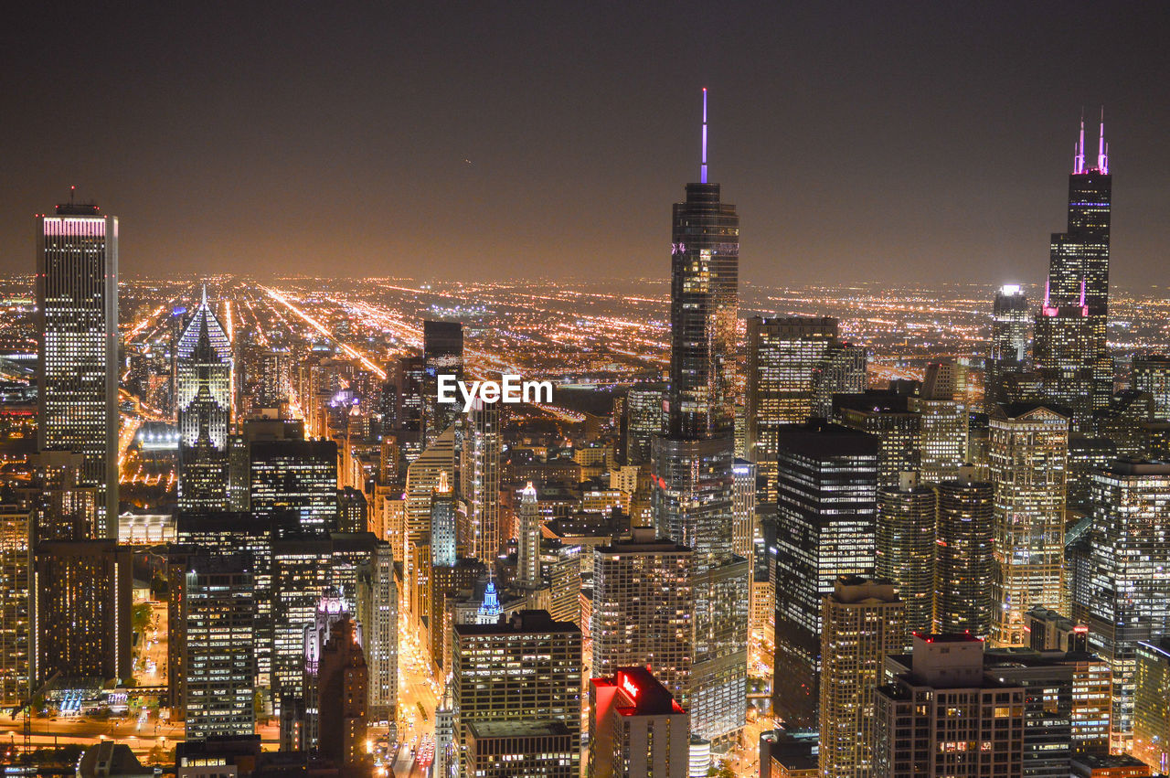 Illuminated cityscape against sky during night