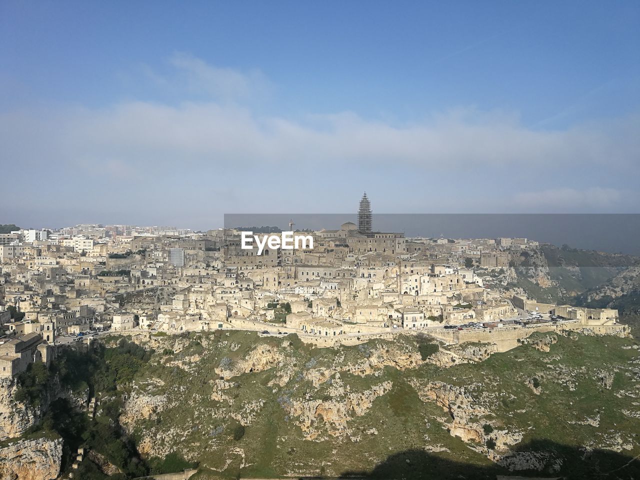 Buildings in city against cloudy sky