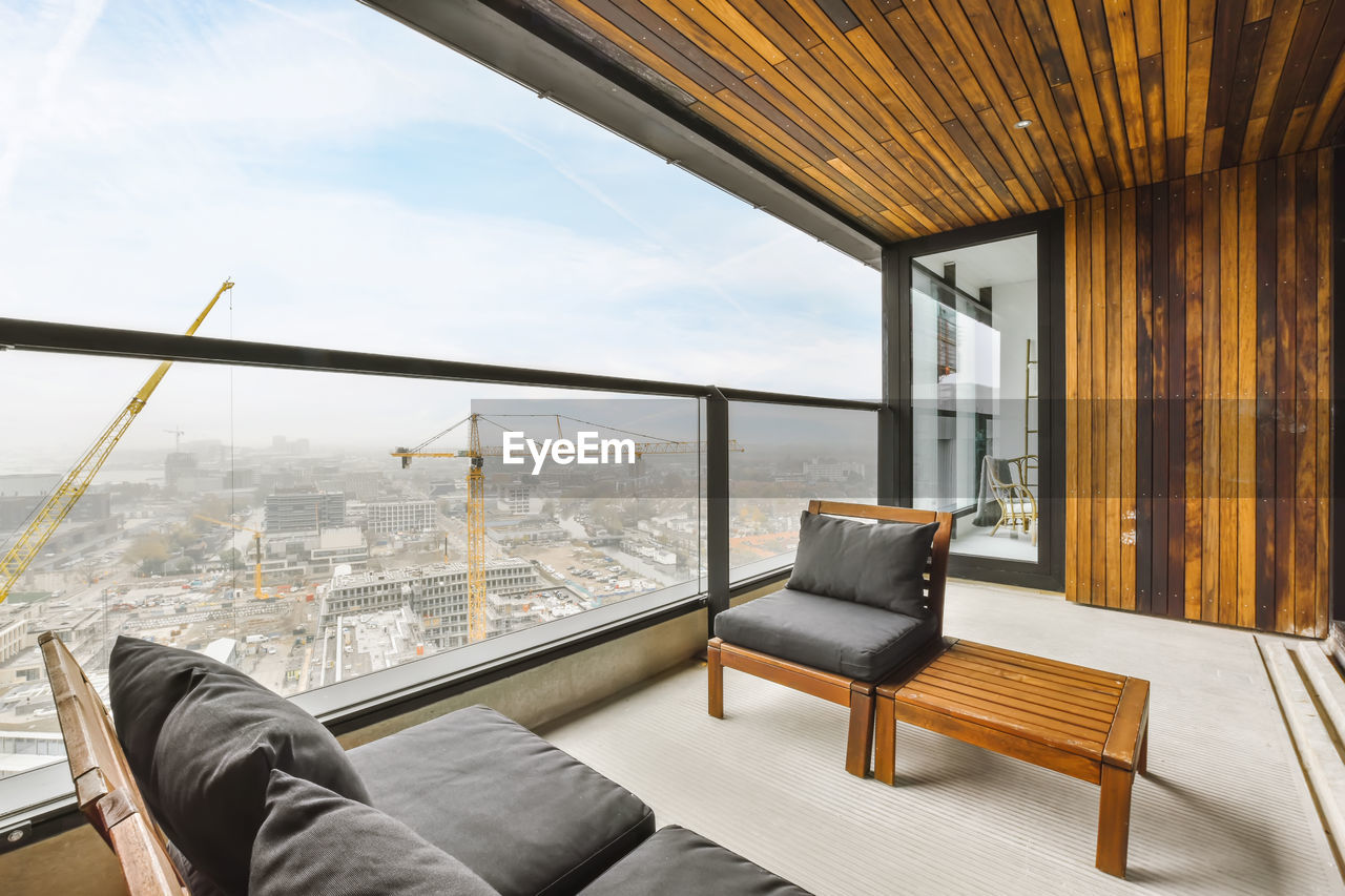 Interior of spacious balcony with soft sofas in new flat in apartment building