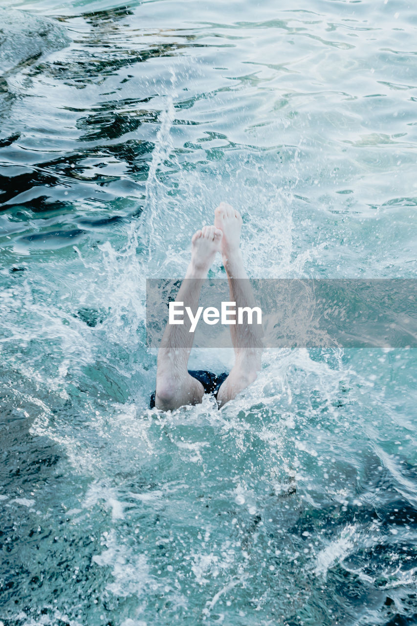 low section of woman swimming in sea