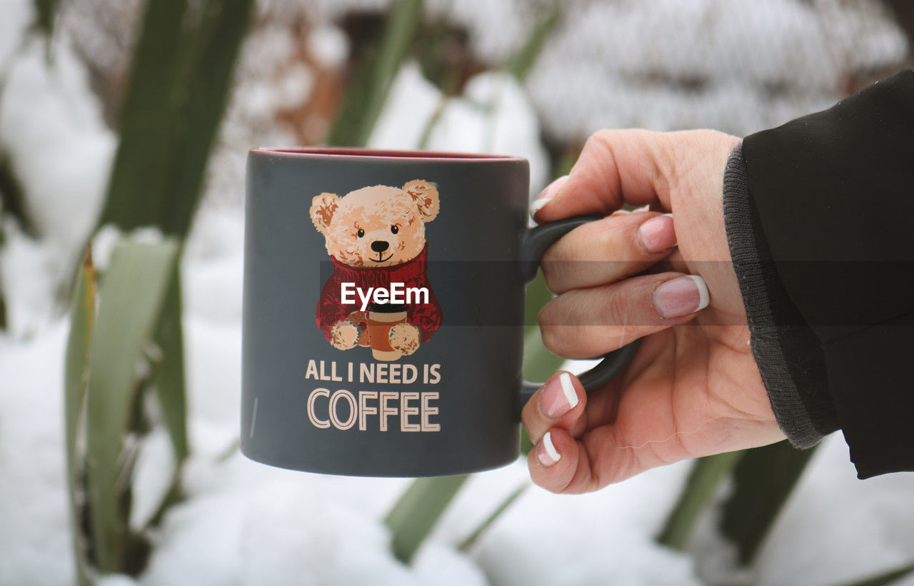 Cropped hand of woman holding cup of coffee