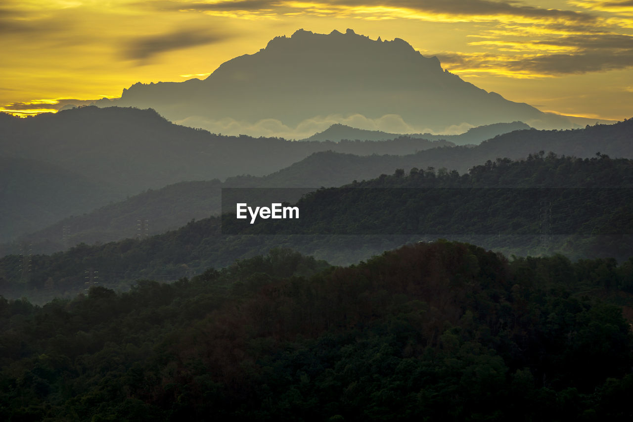 environment, mountain, landscape, scenics - nature, nature, sky, land, fog, sunrise, beauty in nature, tree, morning, forest, dawn, cloud, mountain range, sun, plant, travel, mountain peak, twilight, tranquility, no people, outdoors, travel destinations, mist, sunlight, sunbeam, wilderness, tourism, valley, tranquil scene, rural scene, yellow, silhouette, horizon, summer, non-urban scene, social issues, dramatic sky, holiday, atmospheric mood, idyllic, vacation, igniting, trip