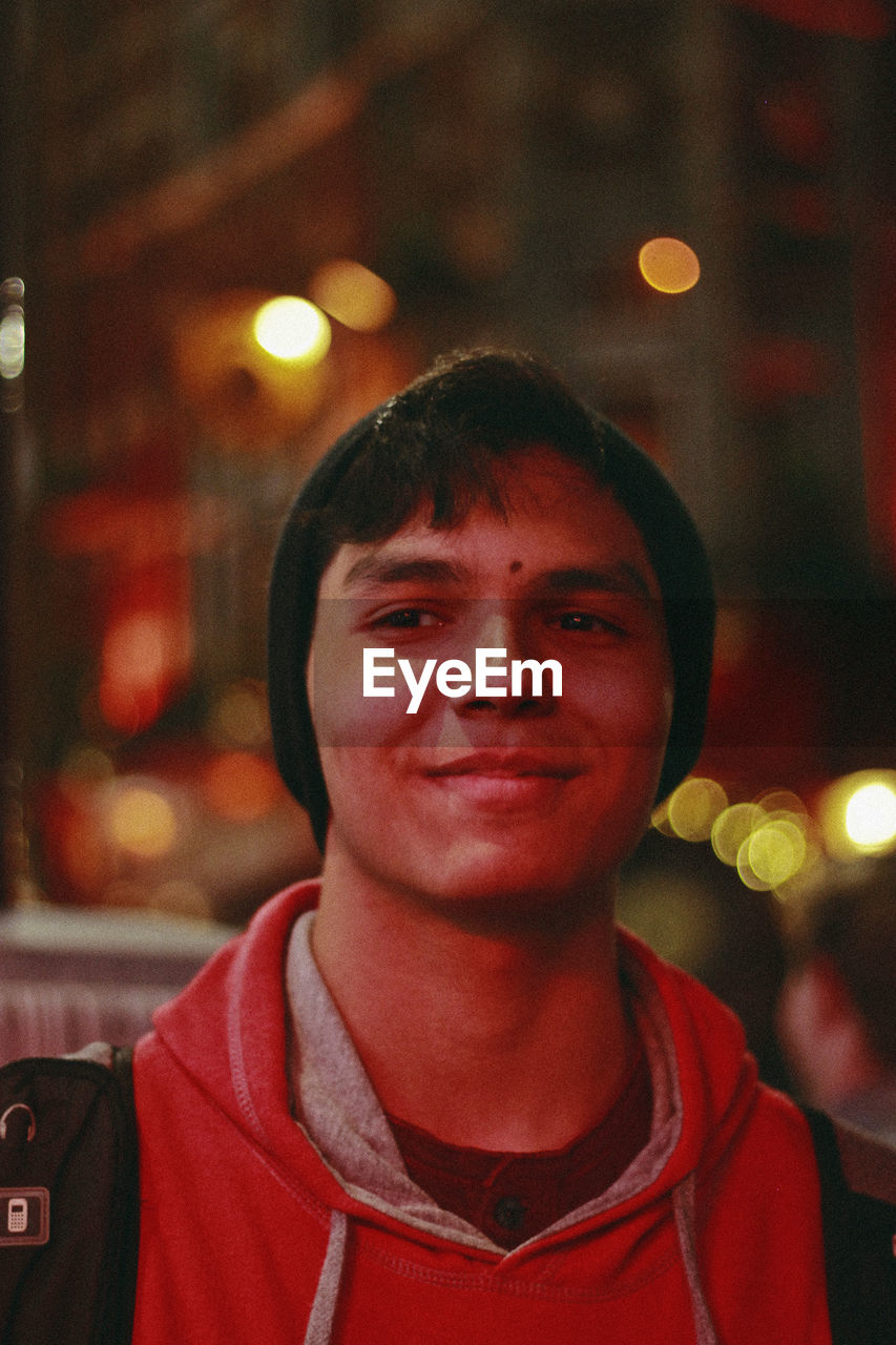 Smiling young man looking away at night