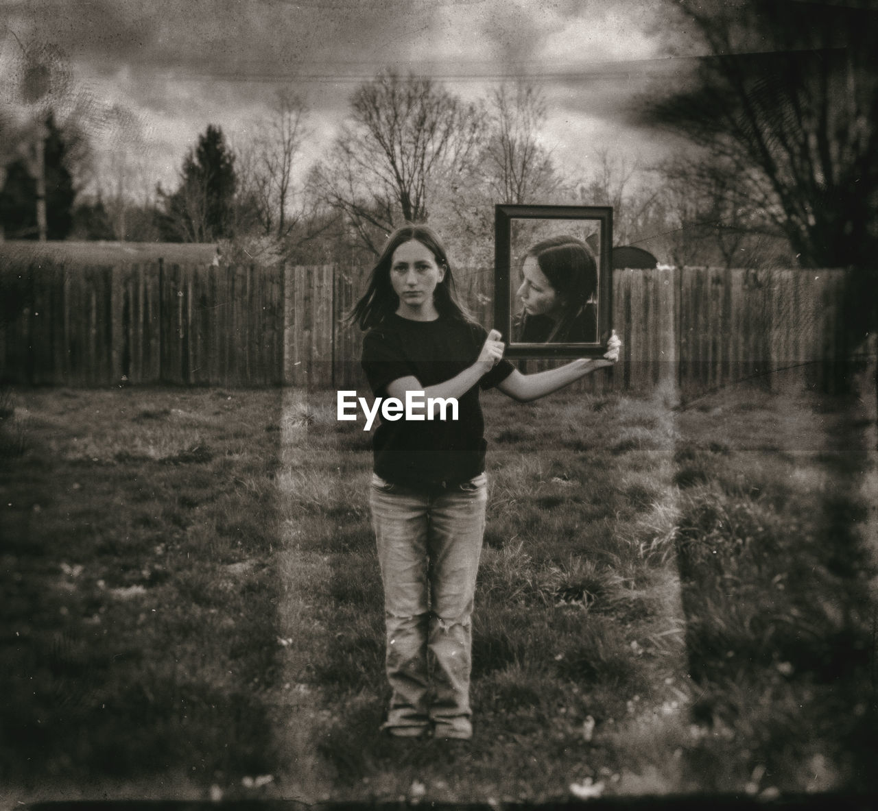 PORTRAIT OF TEENAGE GIRL STANDING ON FIELD