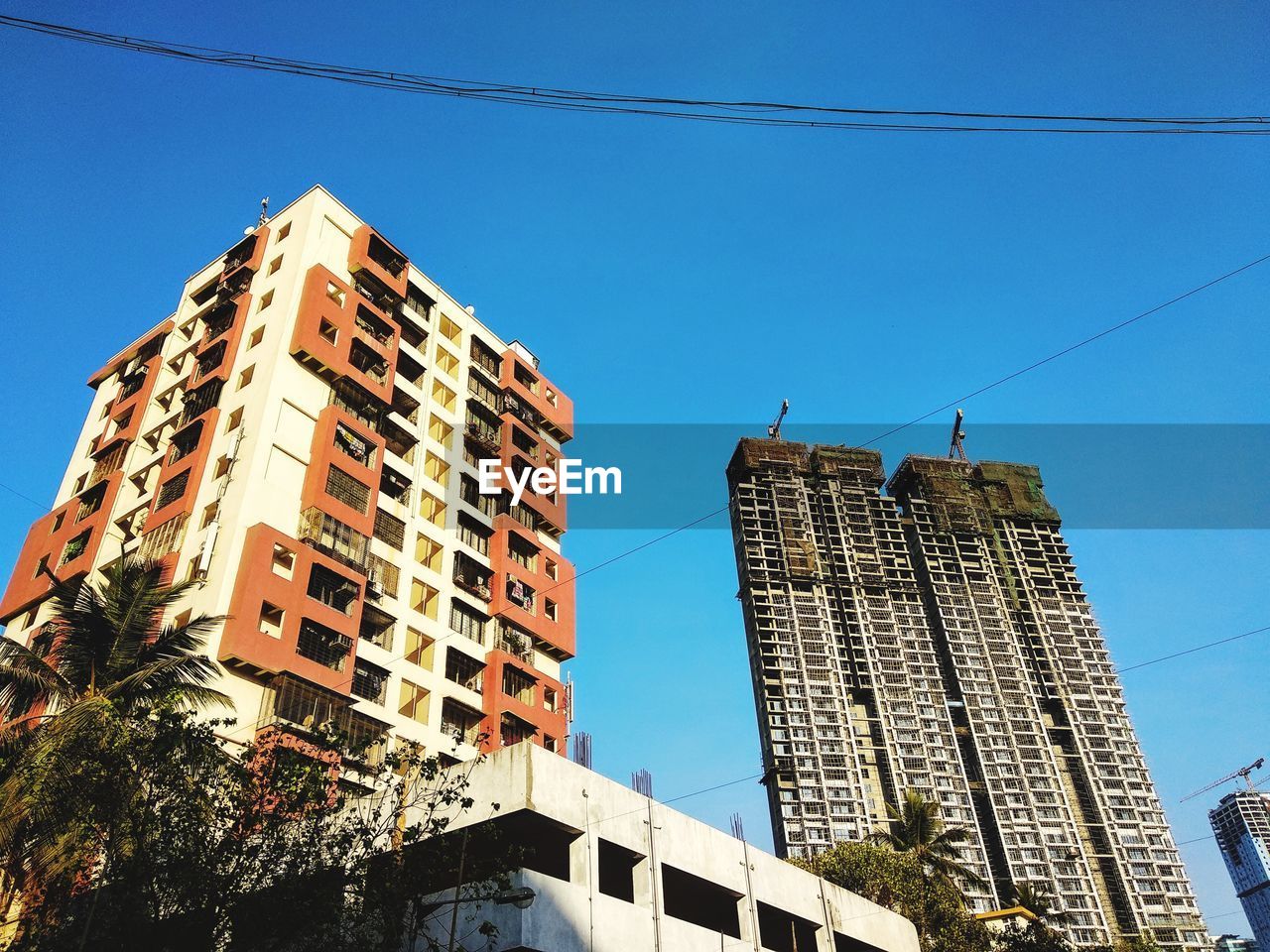 LOW ANGLE VIEW OF TALL BUILDINGS AGAINST CLEAR BLUE SKY