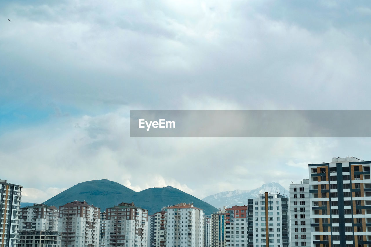 Buildings in city and erciyes mountain against sky
