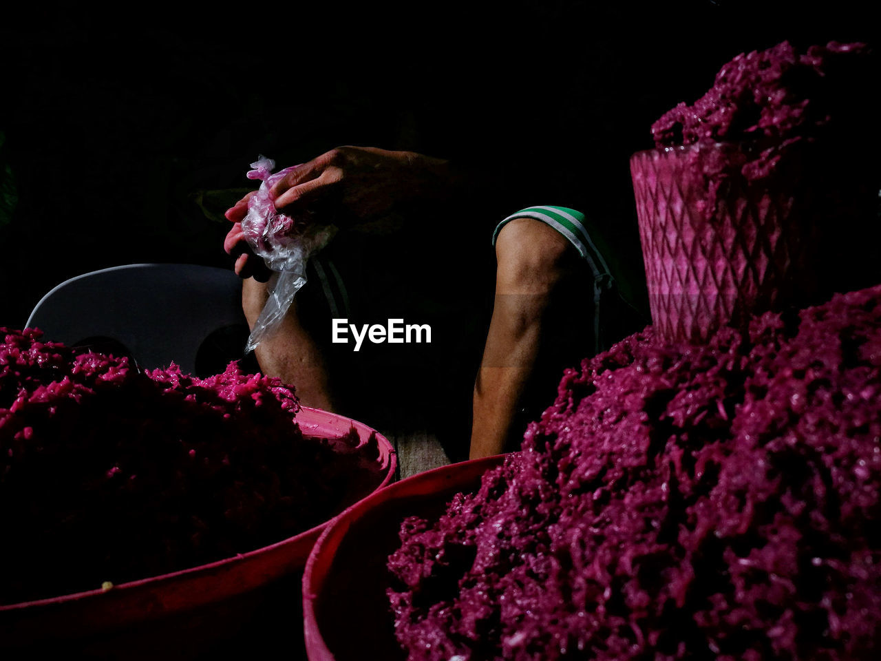 Midsection of market vendor selling shrimp paste at street market during night