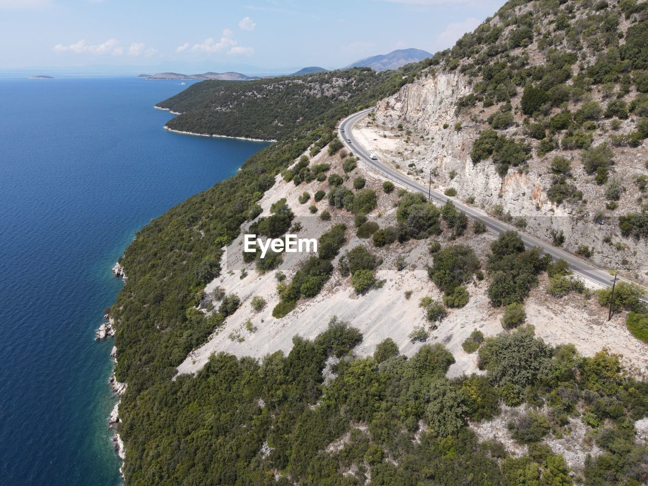 HIGH ANGLE VIEW OF STREET AMIDST SEA AGAINST SKY