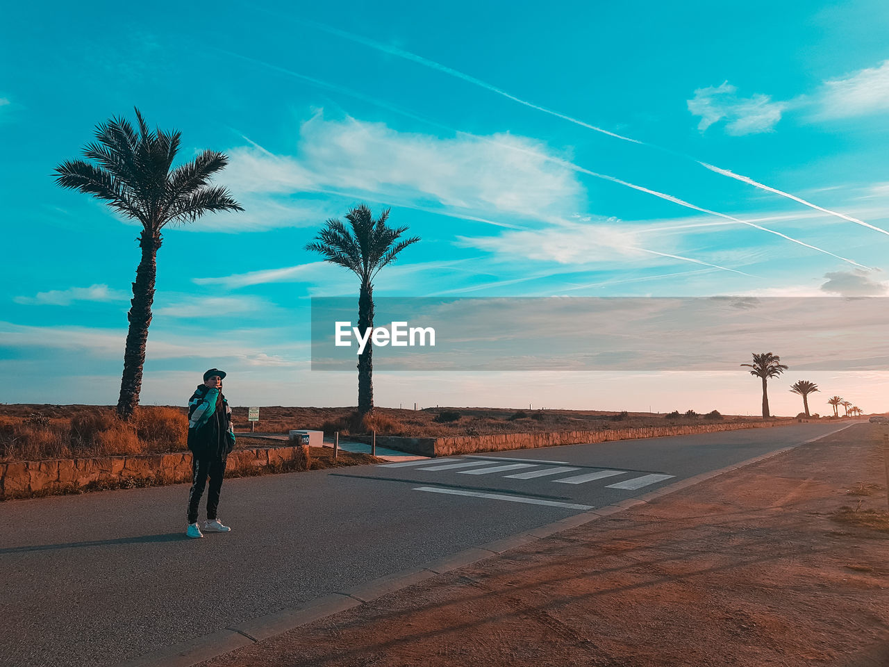 Man standing on road against sky