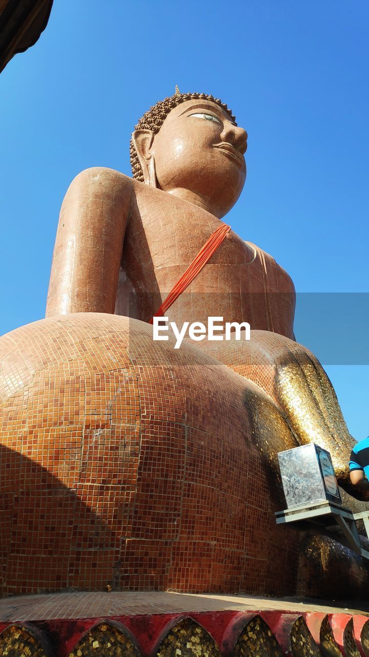 LOW ANGLE VIEW OF STATUE AGAINST TEMPLE AGAINST BLUE SKY AGAINST CLEAR BACKGROUND