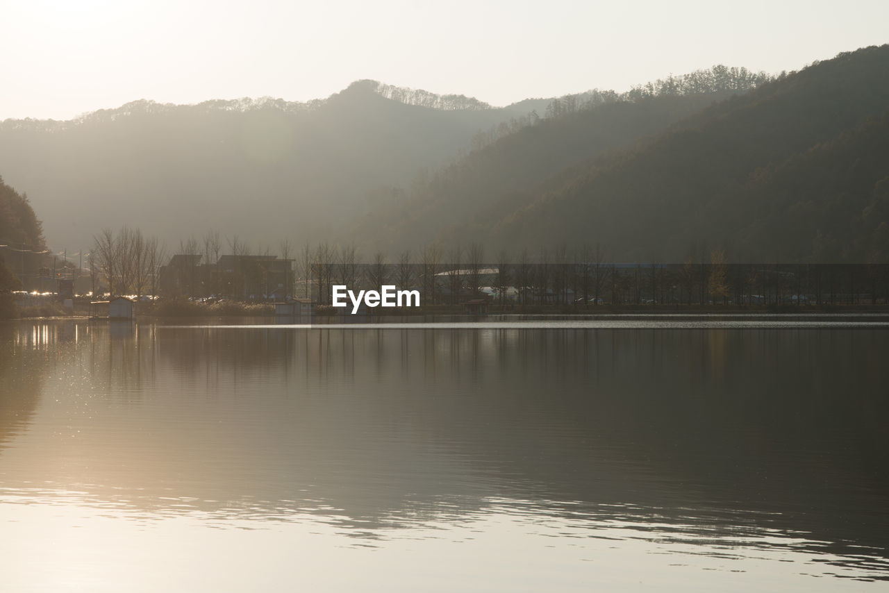 Scenic view of lake by mountains against sky