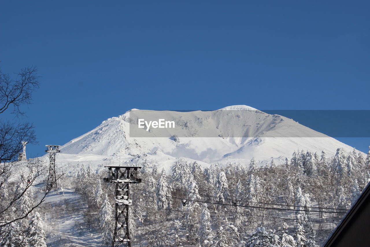 Scenic view of snowcapped mountains against clear blue sky