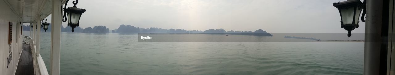 PANORAMIC SHOT OF LAKE AGAINST CLOUDY SKY