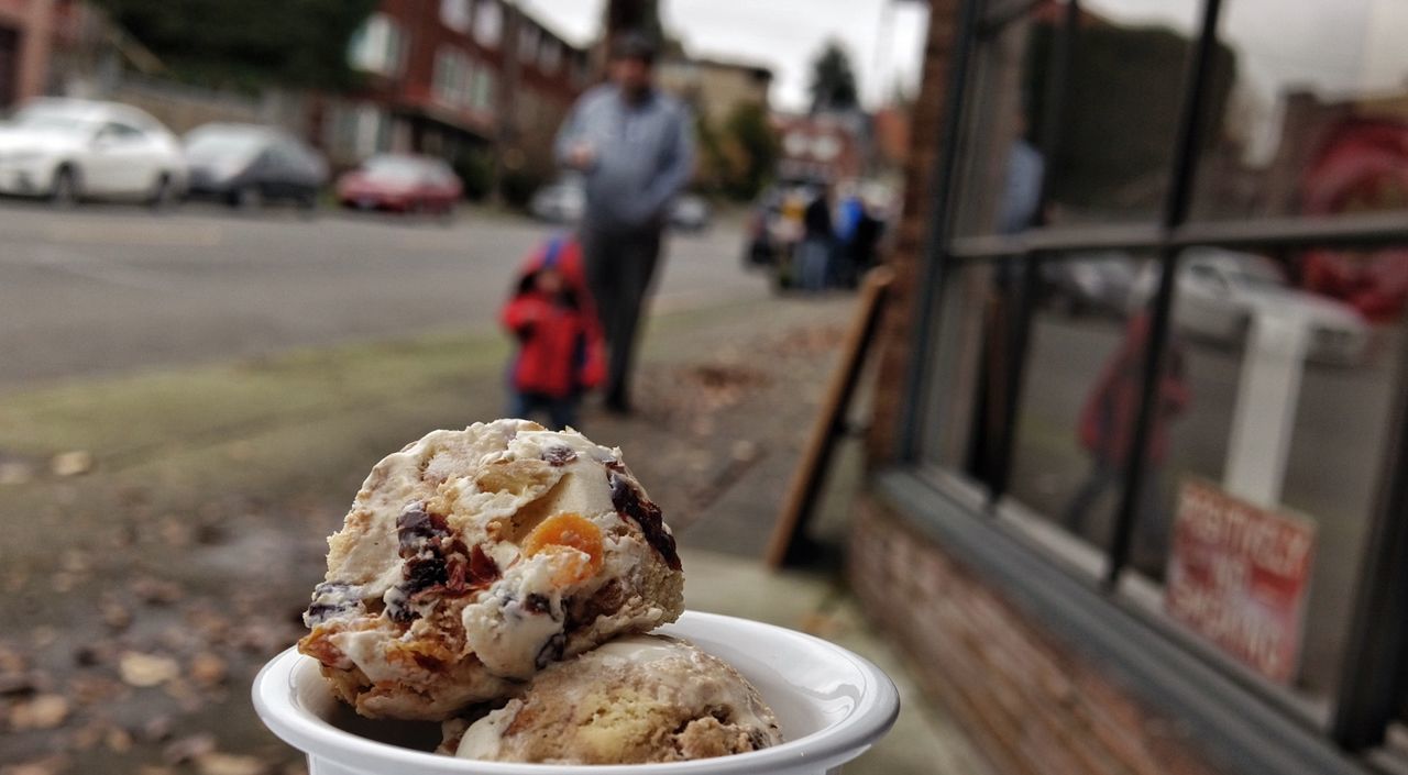 Close-up of ice cream against people walking on sidewalk