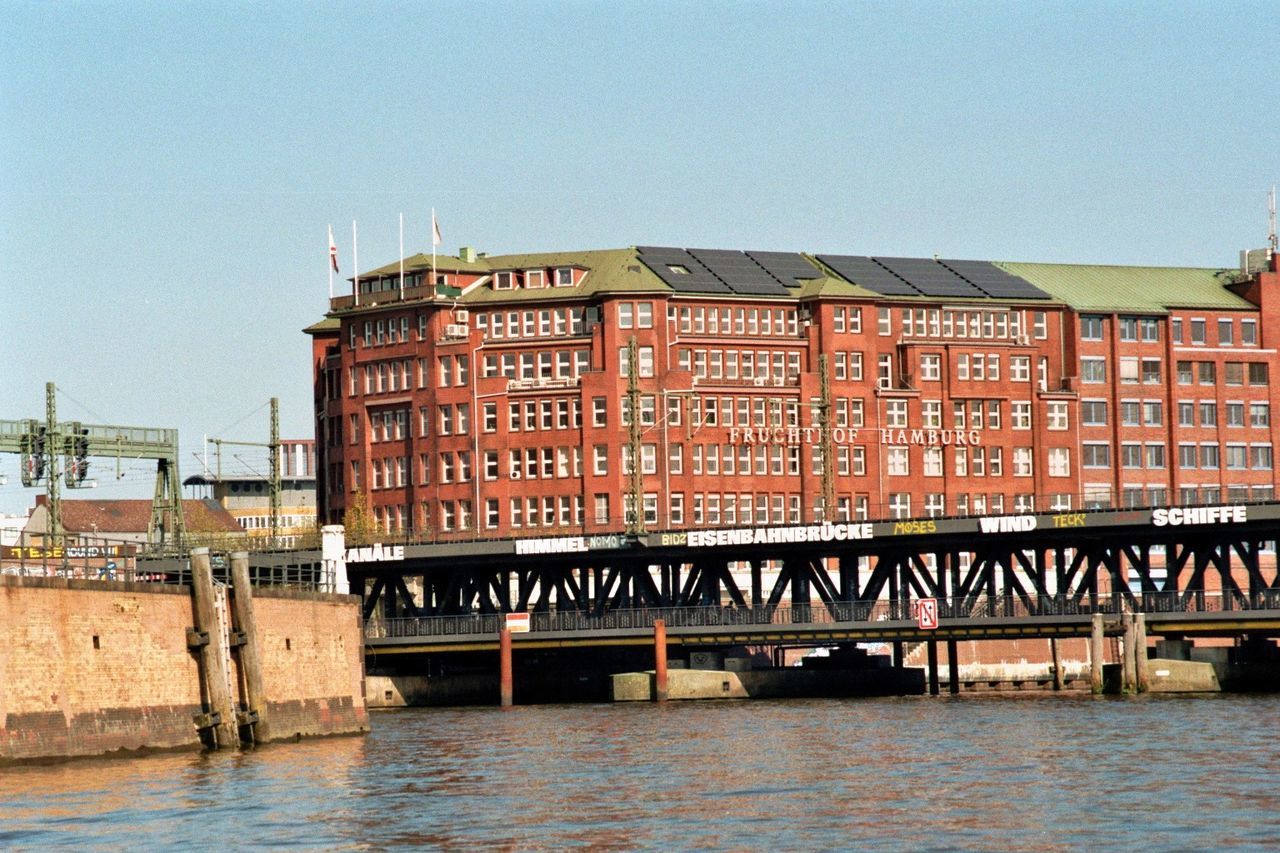 ABANDONED BUILDING BY RIVER IN CITY