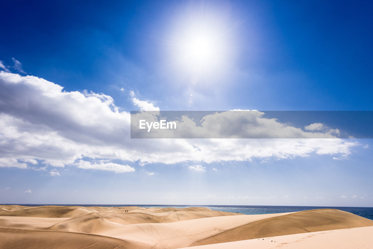 Scenic view of sand dunes against sky