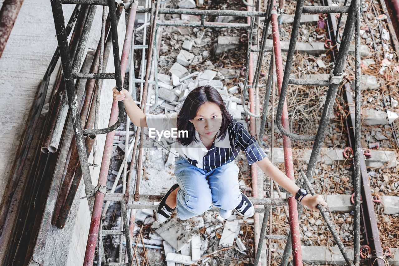 High angle view of girl sitting in abandoned building