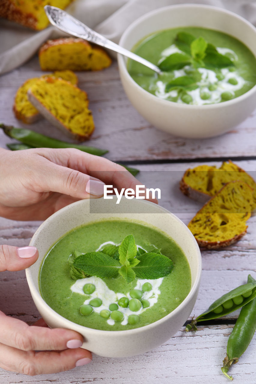Chilled soup puree of green peas, seasoned with green onion, mint and crunchy toasted diced bread