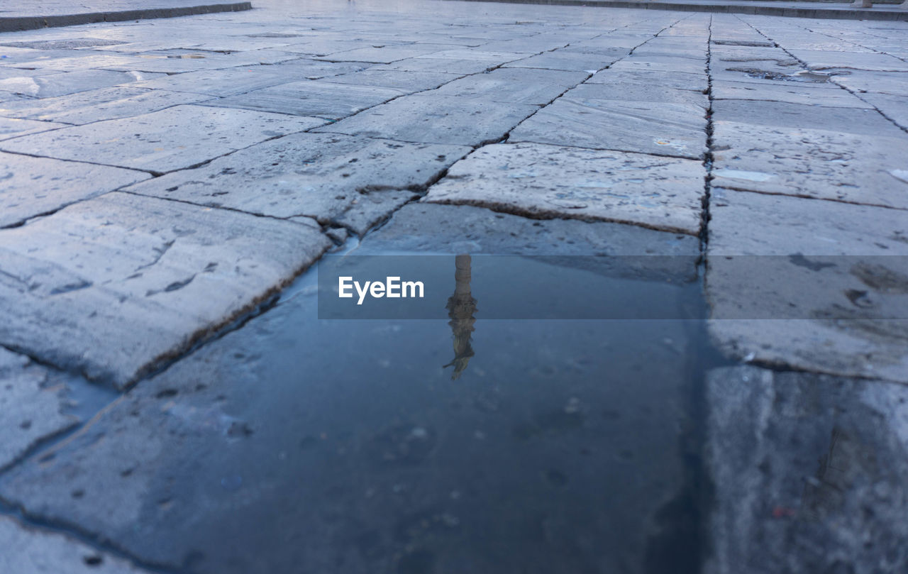 HIGH ANGLE VIEW OF PUDDLE ON GROUND