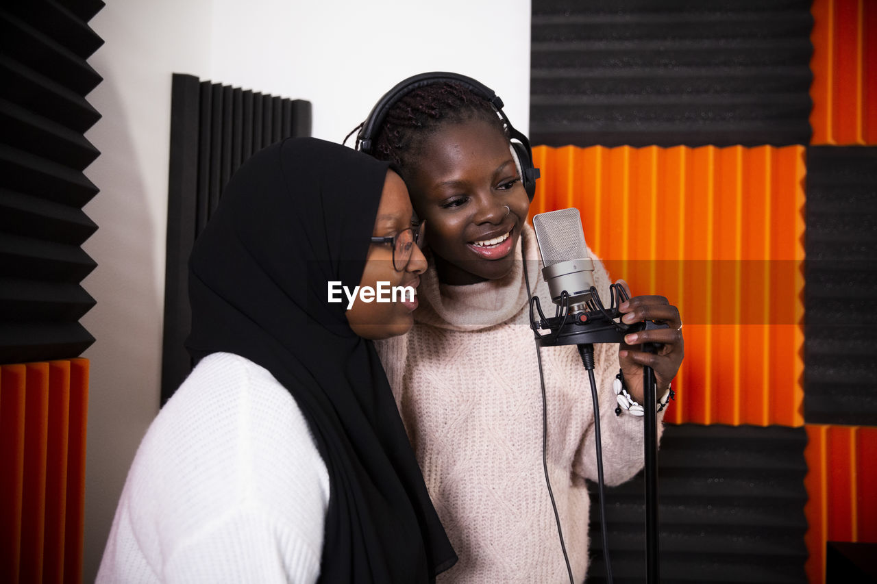 Female singers recording song in studio