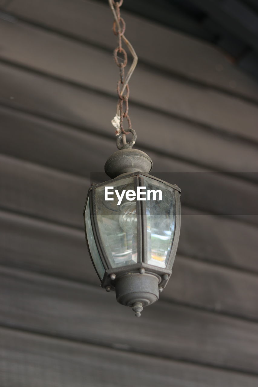 Low angle view of lamp hanging against wall