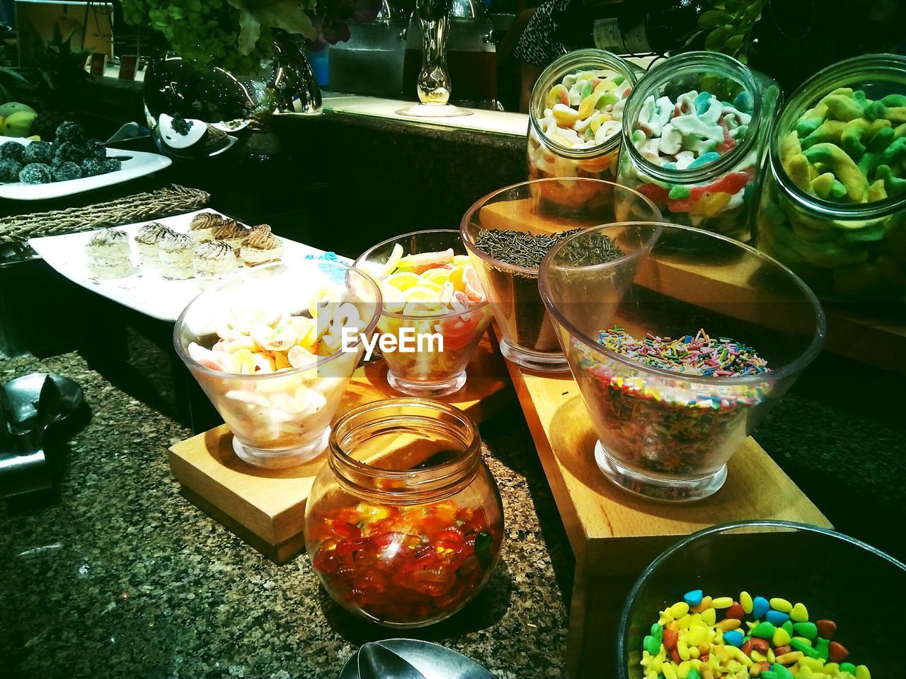 Various candies in container on table