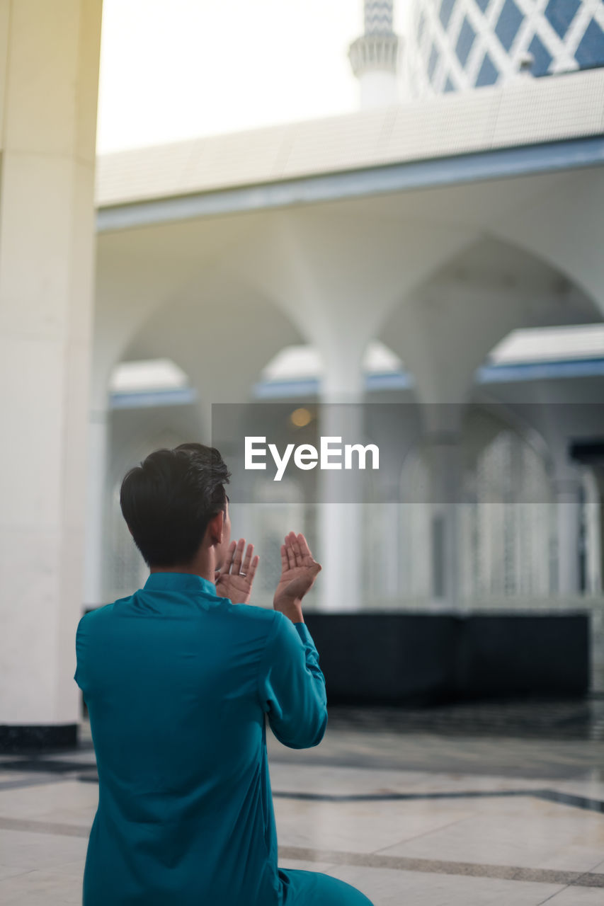 Rear view of man standing in mosque