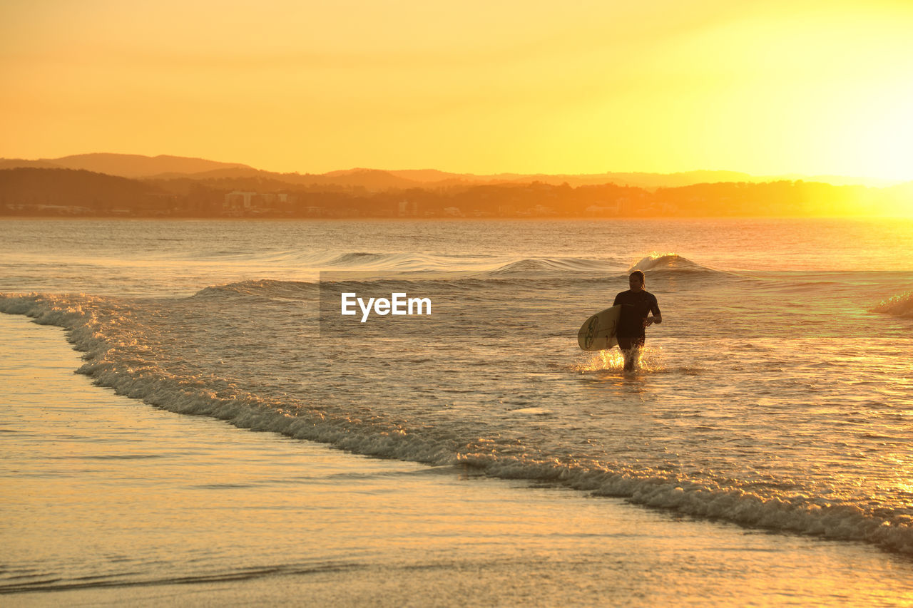 SILHOUETTE MAN AT BEACH DURING SUNSET