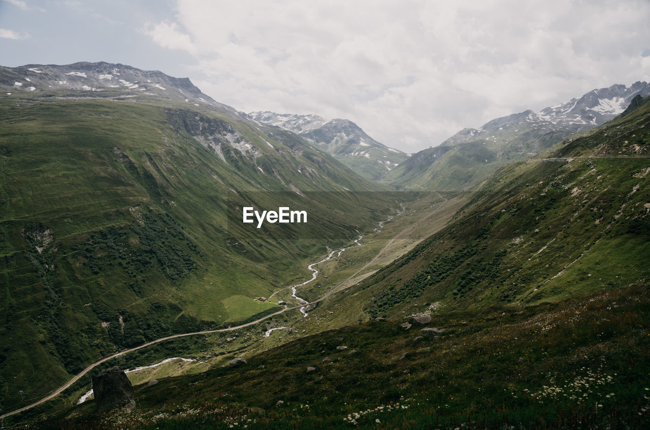 Scenic view of valley and mountains against sky