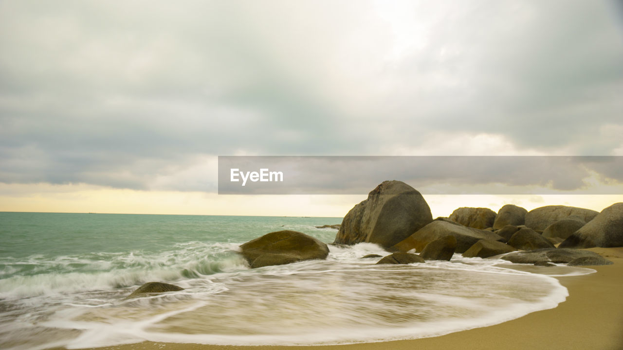 Rocks on beach against sky