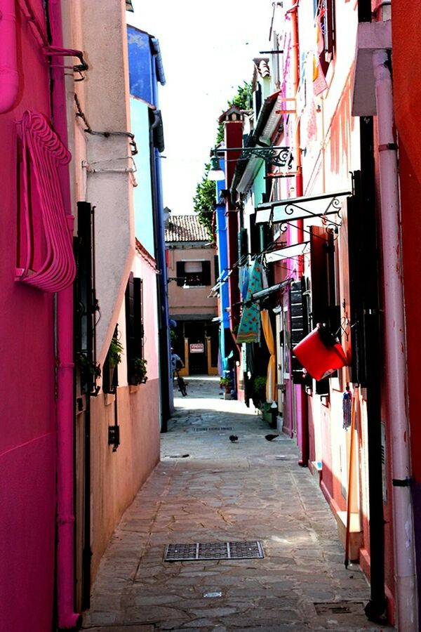 NARROW ALLEY WITH BUILDINGS IN BACKGROUND