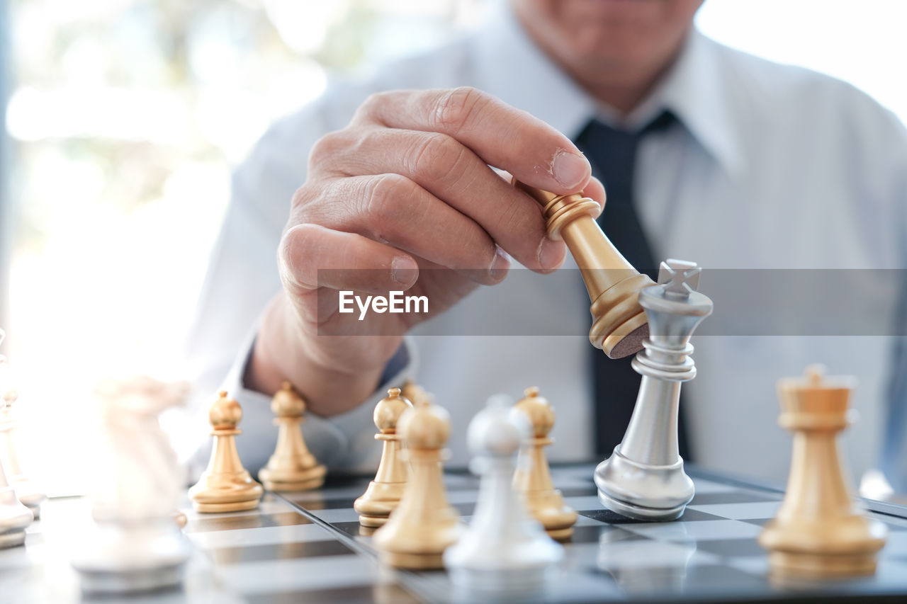 Close-up of businessman playing chess